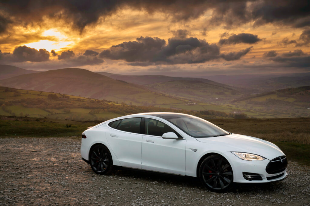 Sleek Tesla Model S P85 in Stunning Sunset Landscape Wallpaper