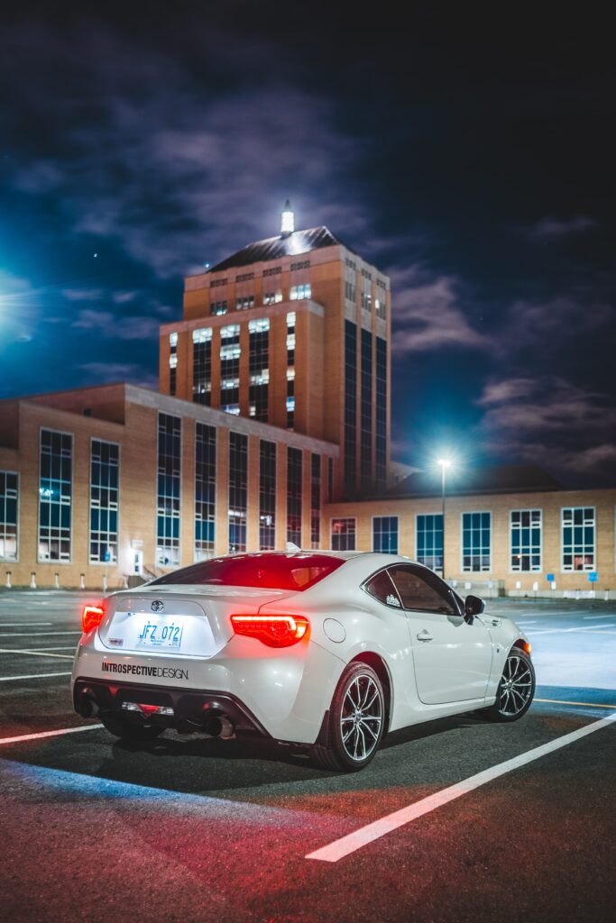 Elegant White Toyota Car at Night in Modern Building Parking Wallpaper