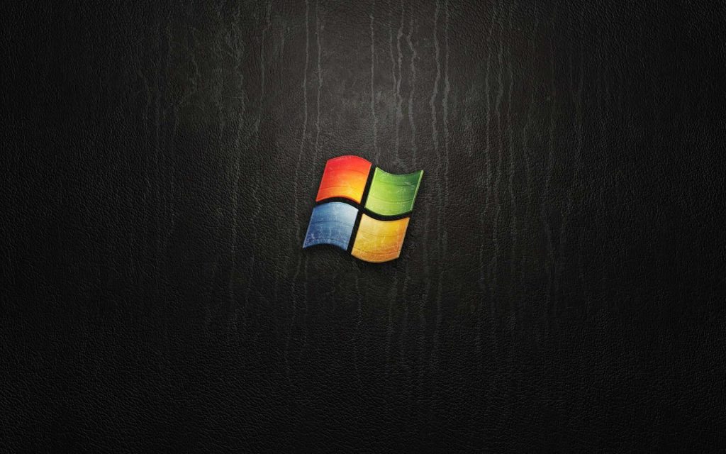 Sleek Windows Vista wallpaper with vibrant logo on textured black leather background for desktop