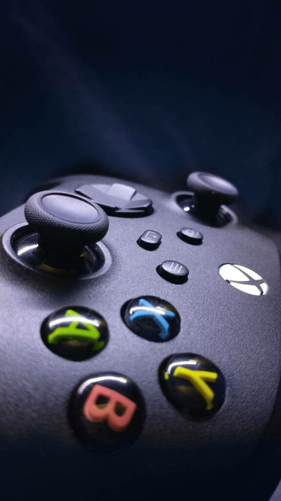 Gleaming Colors and Matte Elegance: A Captivating Close-Up of the Xbox Series X Controller's Button Array Wallpaper