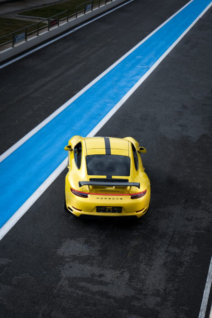 Sleek Yellow Porsche 911 Wallpaper on Racetrack - Speed & Elegance