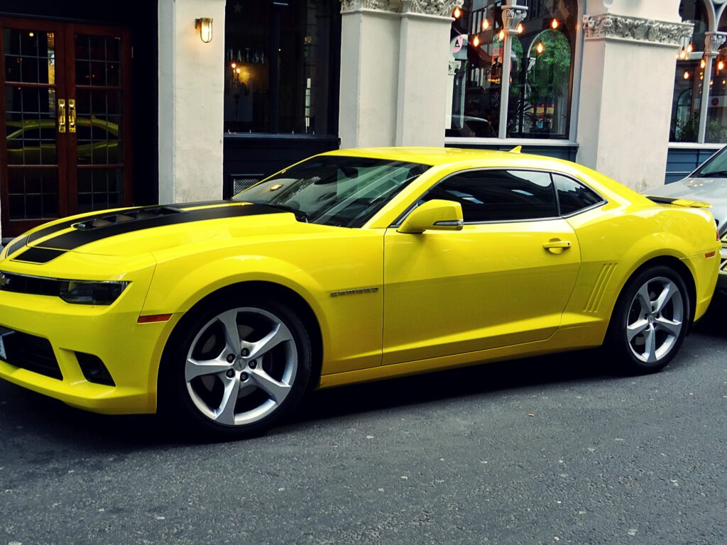 Sleek Yellow Sports Car Wallpaper: Dynamic Design & Urban Backdrop