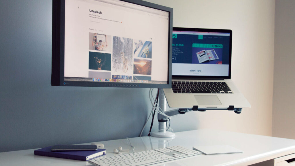 Minimalistic Workspace: Sleek Desk Setup with VGA-Connected Monitor and Laptop Wallpaper
