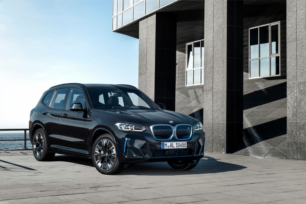Sleek and Shining: Captivating Black BMW ix3 M Sport Car Parked, Embracing the Sun's Radiance Wallpaper