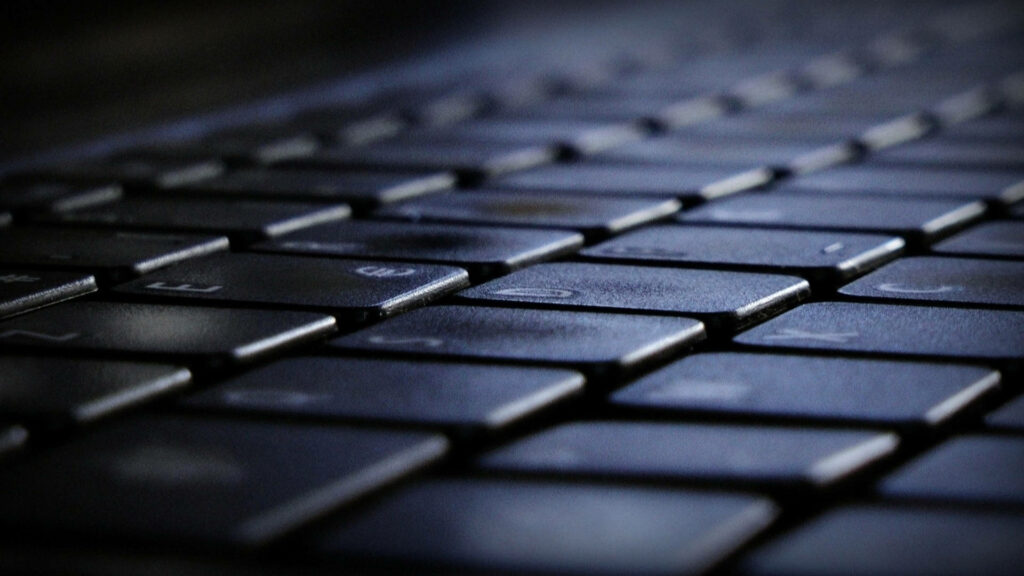 Sleek and Stylish: A Captivating Close Up of a Minimalist Black Computer Keyboard Wallpaper
