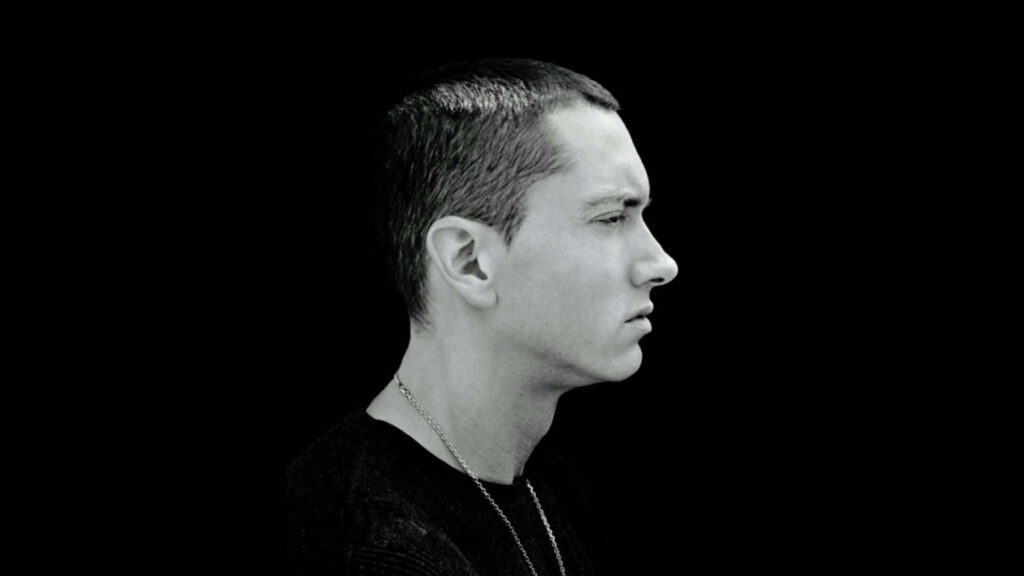 Black and white side profile of Eminem Slim Shady with intense expression on solid black background Wallpaper