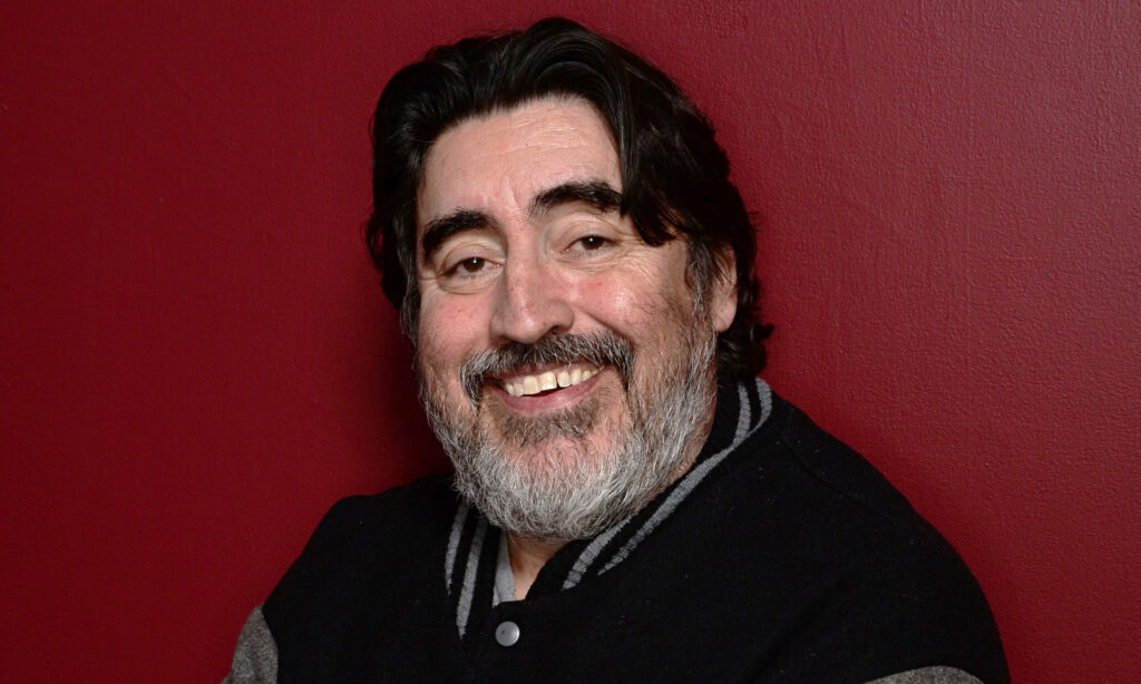 Smiling Alfred Molina portrait wallpaper deep red background relaxed approachable actor