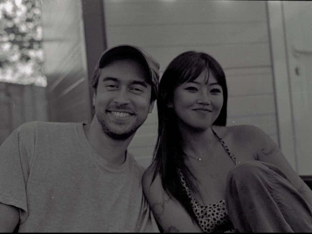 Monochrome portrait of smiling couple Alex G outdoors radiating warmth and candid happiness wallpaper