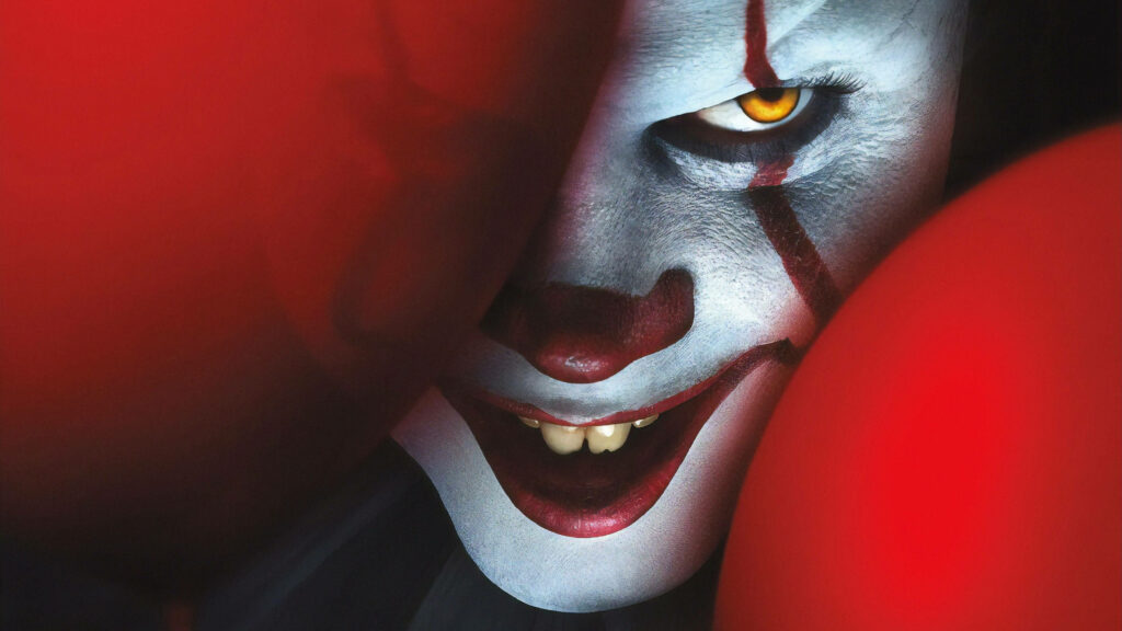 Grinning Menace: Pennywise from 'It' Strikes Again in Creepy Wallpaper