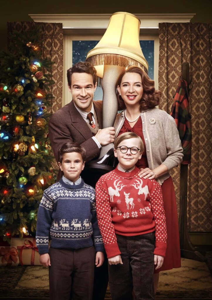 Smiling family in festive sweaters by decorated Christmas tree holding unique holiday lamp Wallpaper