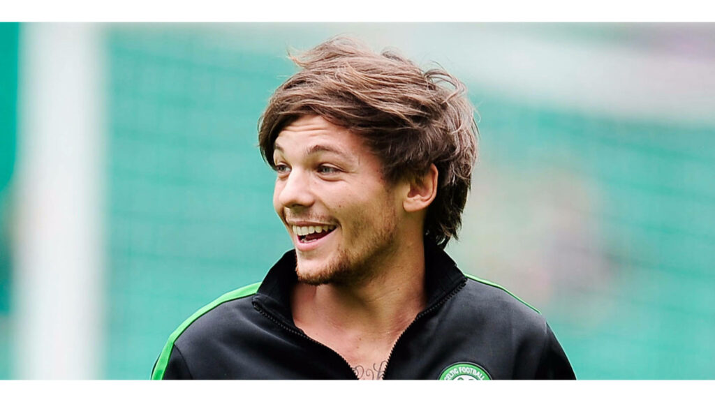 Beaming Louis Tomlinson showcases athletic style in a charismatic candid capture Wallpaper