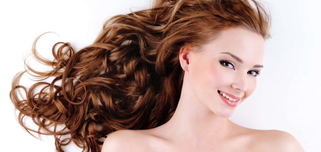 Smiling model with voluminous wavy chestnut hair in studio portrait on white background Wallpaper