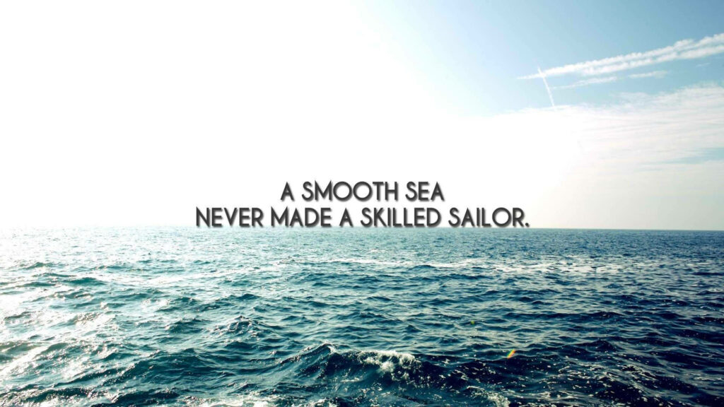 Sunlit ocean waves with quote A smooth sea never made a skilled sailor motivational wallpaper