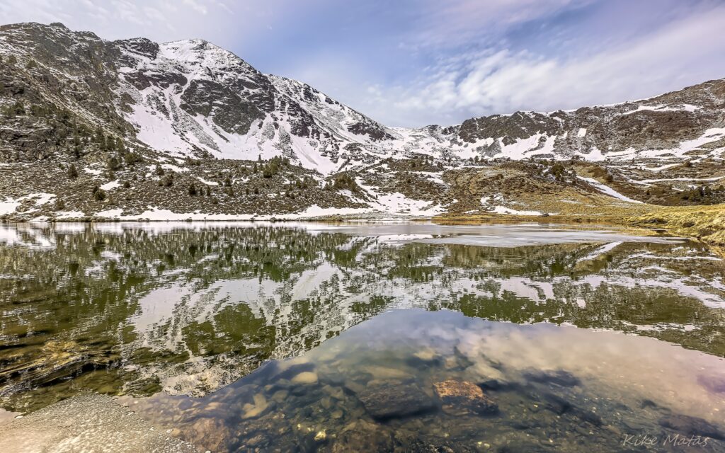 Snow-capped mountain peaks reflected in a calm alpine lake serene natural landscape wallpaper