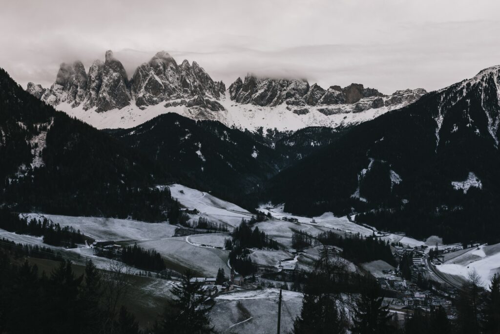 Aerial view of snow-covered Dolomites in Italy with misty peaks and frosty fields winter wallpaper
