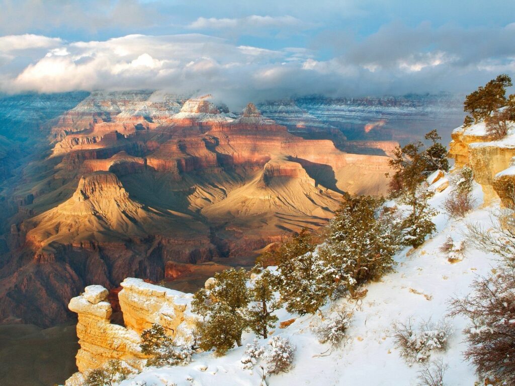 Snow-dusted Arizona canyons with rugged cliffs and winter trees under a cloudy sky wallpaper