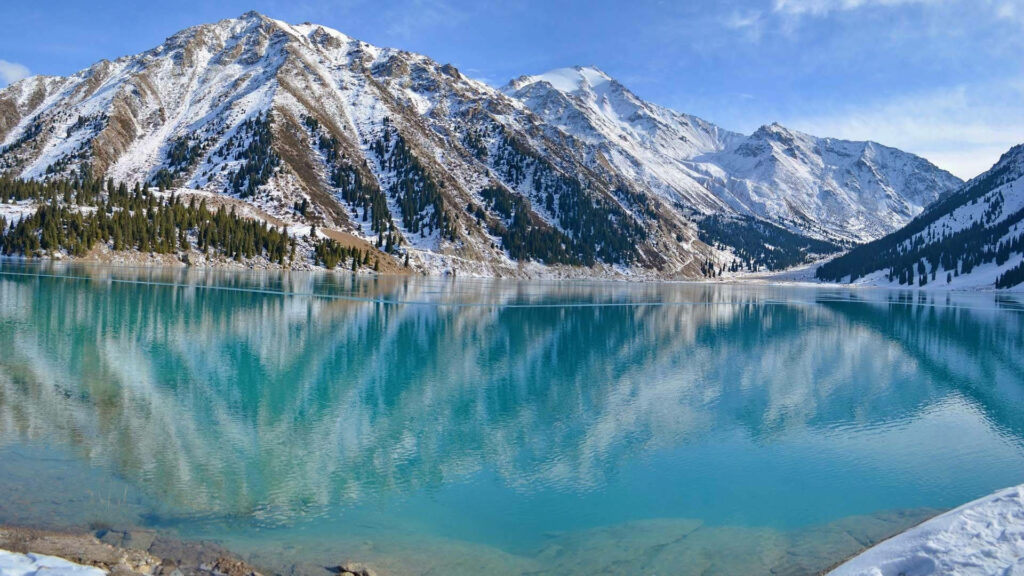 Nature's Majestic Mirror: Capturing the Pristine Big Almaty Lake Embraced by Snow-Covered Peaks Wallpaper