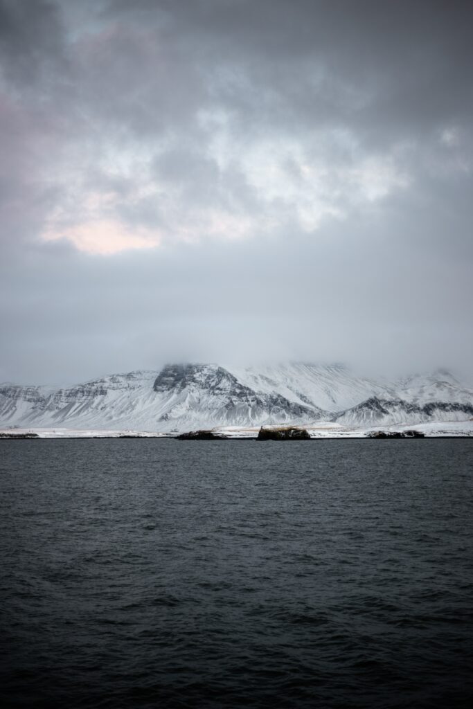Snow-capped mountains near Reykjavik Iceland with icy sea foggy sky tranquil arctic landscape Wallpaper
