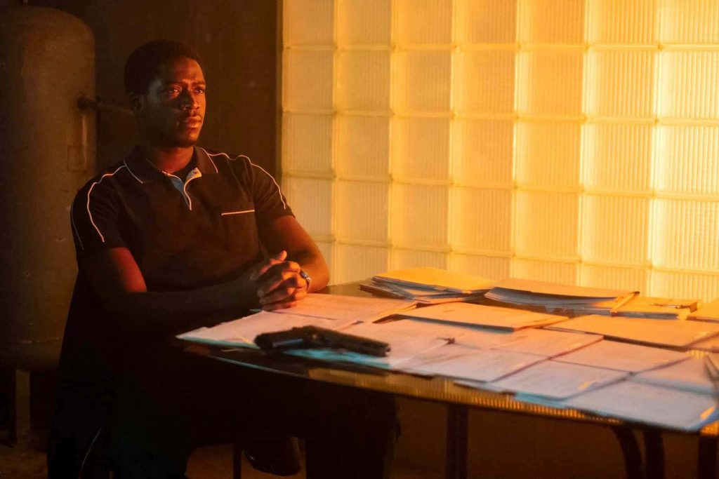 Franklin Saint from Snowfall seated at desk with handgun documents dramatic warm glow wallpaper
