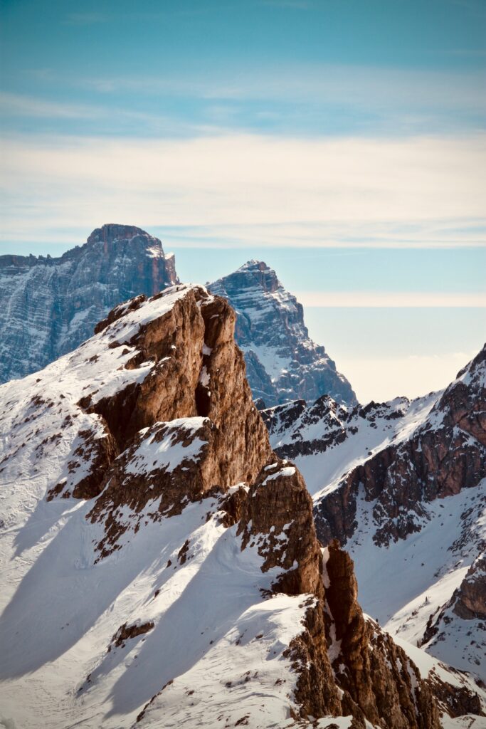 Snowy rugged mountain peaks under a serene sky winter alpine landscape wallpaper background