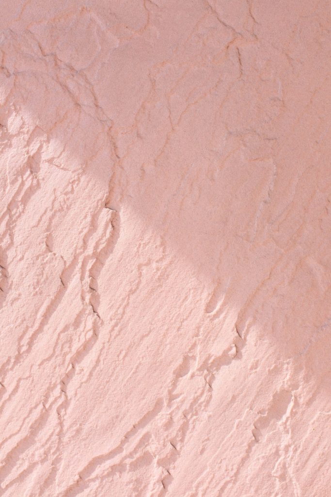 Soft pink sandstone texture with soft light and calming diagonal shadows minimalist wallpaper