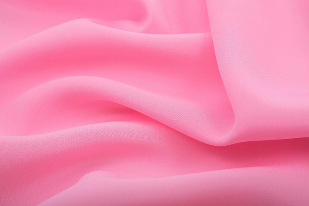 Soft pink fabric wallpaper with flowing folds and smooth texture for calming backgrounds