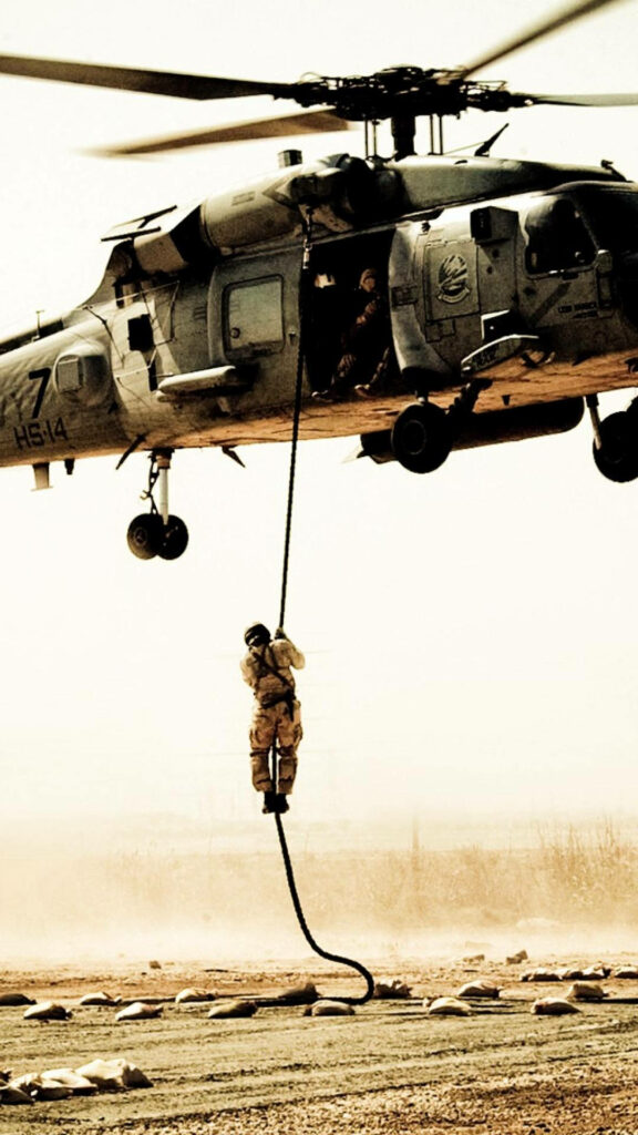 Soldier rappelling from Black Hawk helicopter showing military precision and action in wallpaper