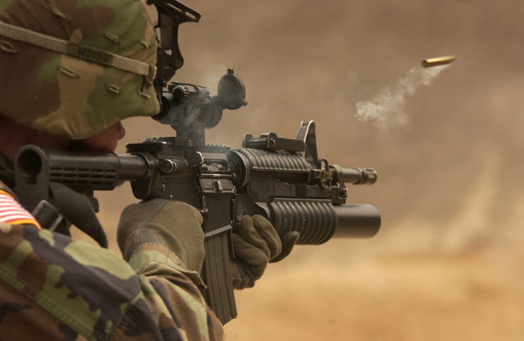 Warrior Unleashed: A Powerful Submachine Gun in Action Wallpaper