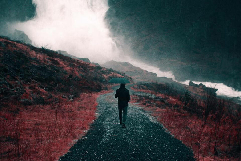 Desolate Desert: A Solitary Figure Braving the Torrential Storm Wallpaper