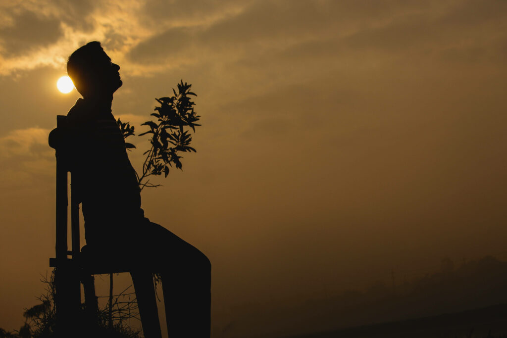 Solitude in the Sun: A Captivating Backlit Portrait of Isolation and Contemplation Wallpaper