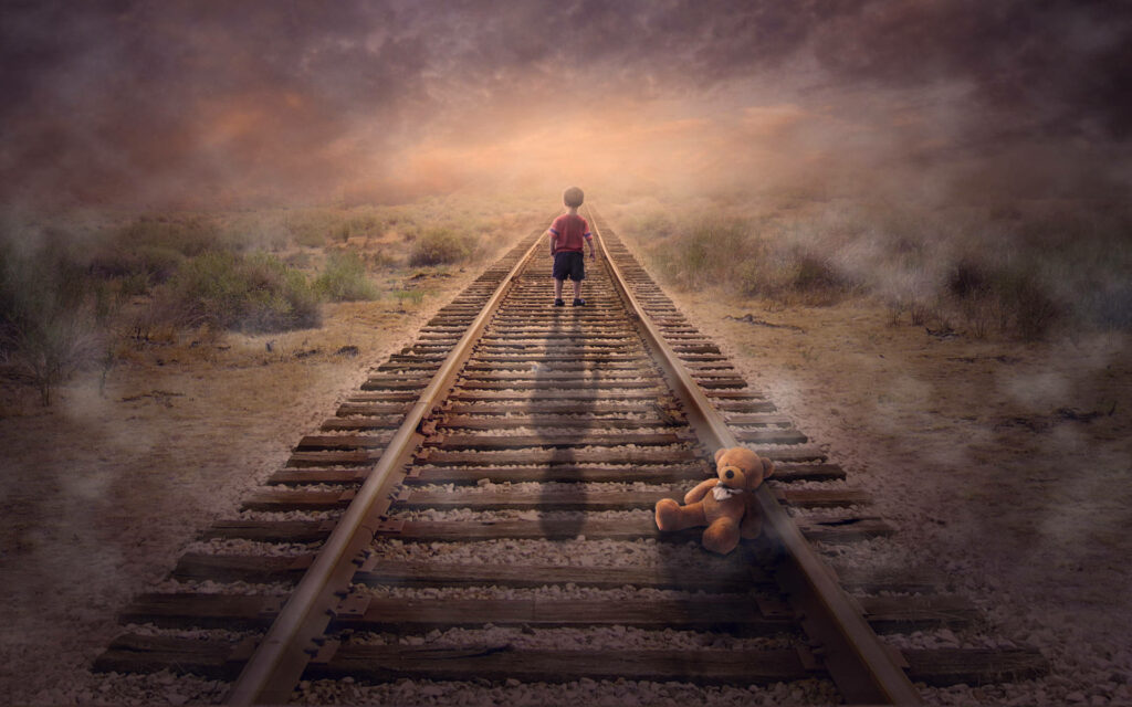 Mysterious Solitude: A Lone Little Boy Immersed in Misty Desert Backdrop Wallpaper