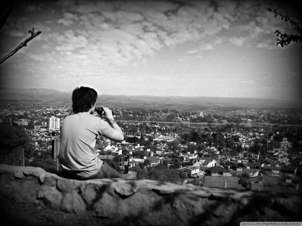 Solitude and Intoxication: A Lone Figure Contemplating the Cityscape under Gloomy Skies Wallpaper