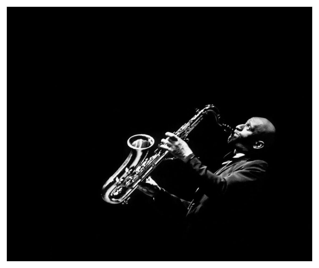 Melodic Shadows: Sonny Rollins Unleashes Soulful Jazz on an Enigmatic Atmosphere Wallpaper