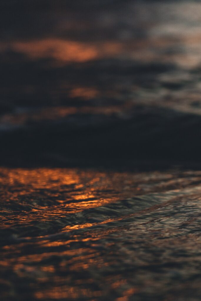 Abstract blurred water ripples with warm orange glow reflecting light soothing wallpaper background