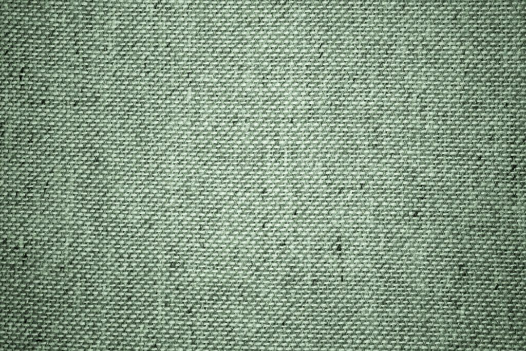 Close-up sage green linen fabric wallpaper texture with soft lighting for calming natural background