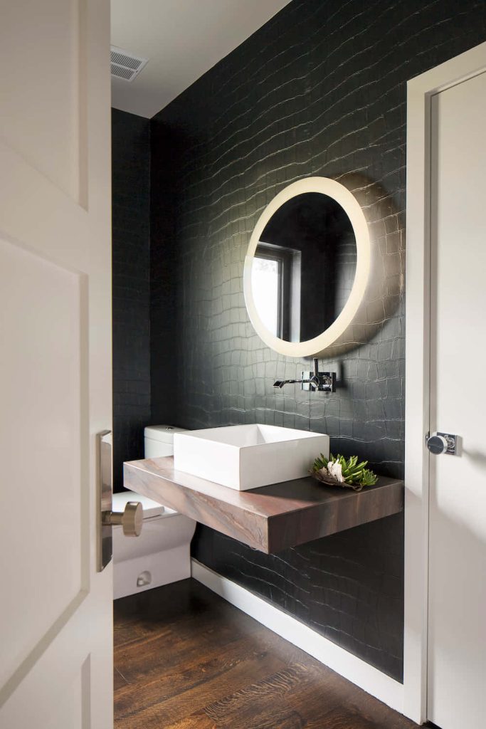 Modern bathroom with black reptilian wallpaper floating wood vanity white vessel sink mirror