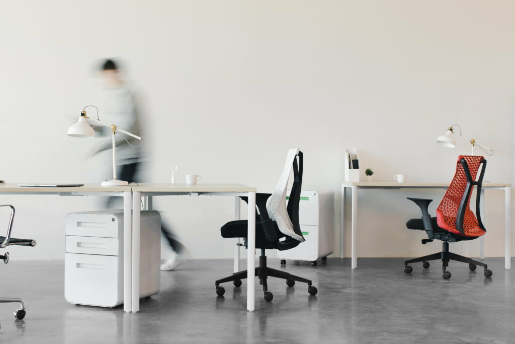 Elegant Office Ambiance: Captivating Woman Seated on Sleek Rolling Chair amidst 5K Wallpaper Bliss