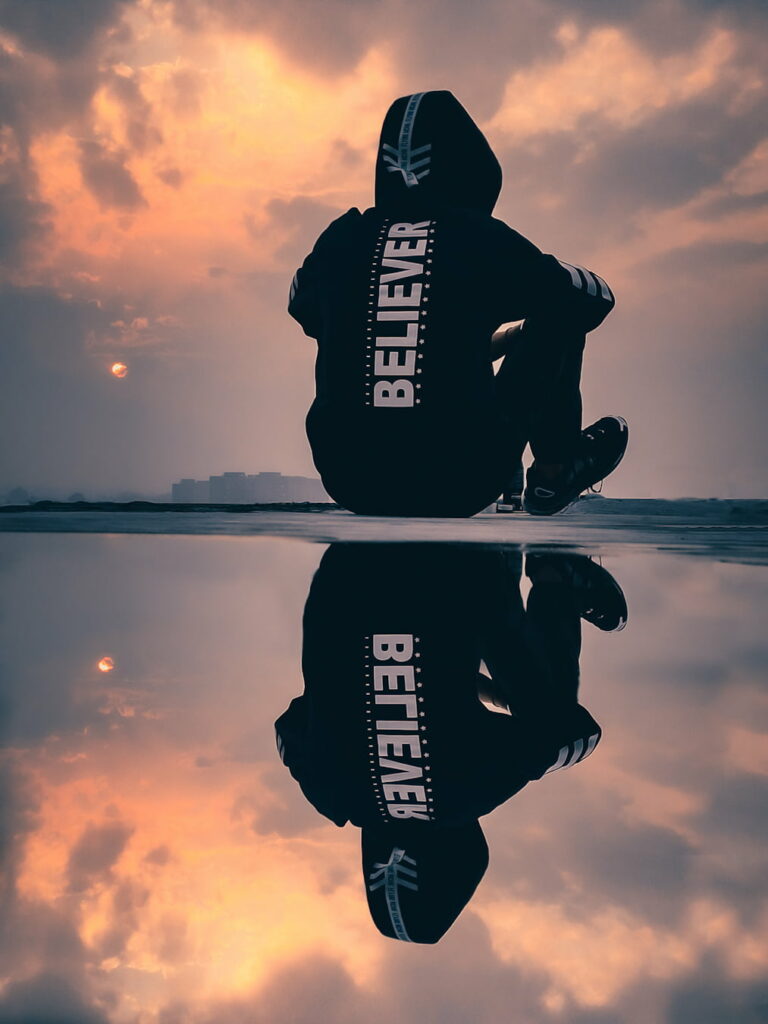 Believer's Reflection: Inspiring Sunset Silhouette of a Boy with Attitude Wallpaper