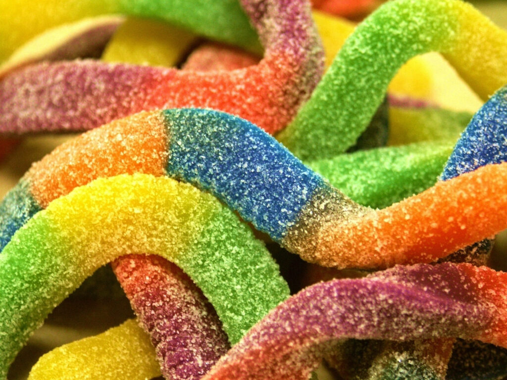 Sugar-Coated Rainbow Treats: Exploring the World of Colorful Sour Worm Candies! Wallpaper