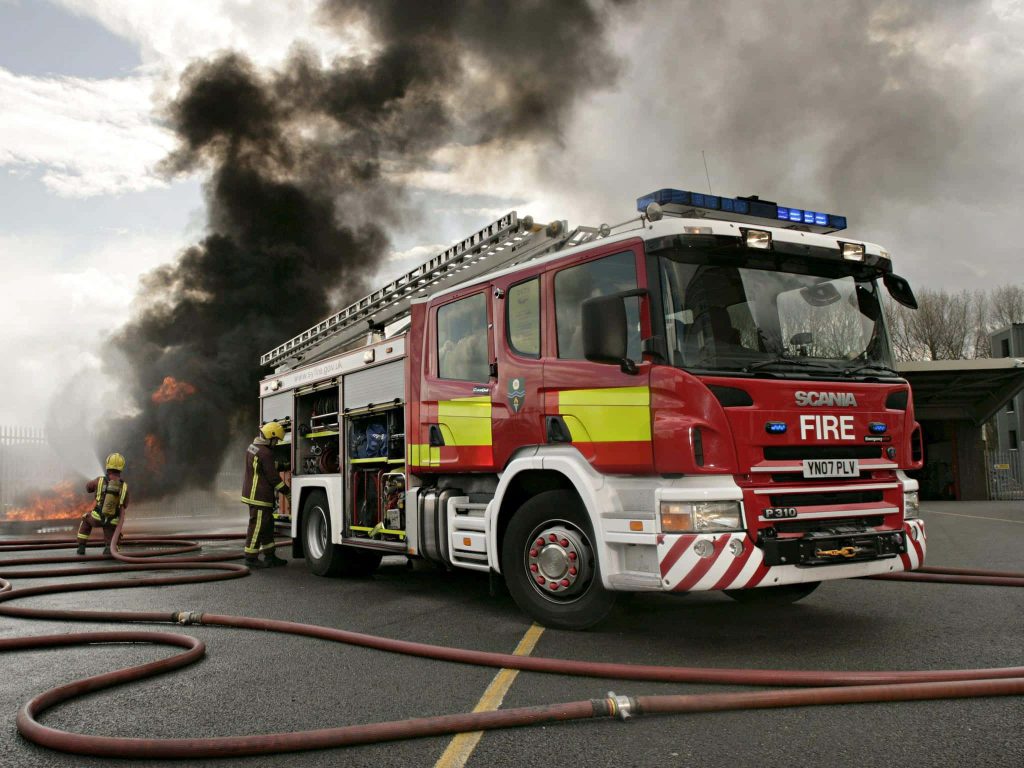 South Yorkshire Fire Rescue Scania P310 fire engine at emergency scene with firefighters battling blaze Wallpaper