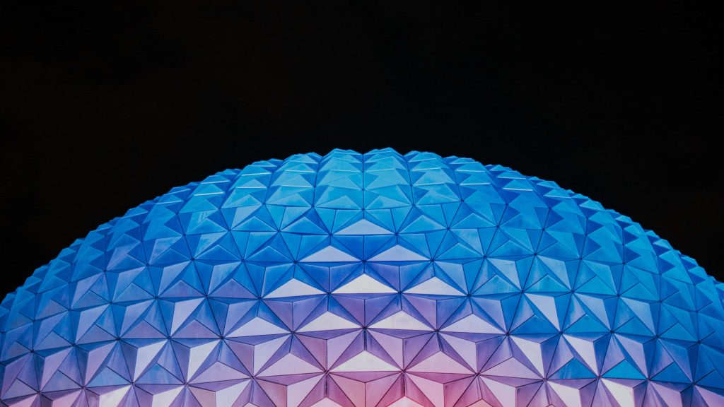 Spaceship Earth at EPCOT glowing blue at night with detailed geodesic dome against black sky Wallpaper