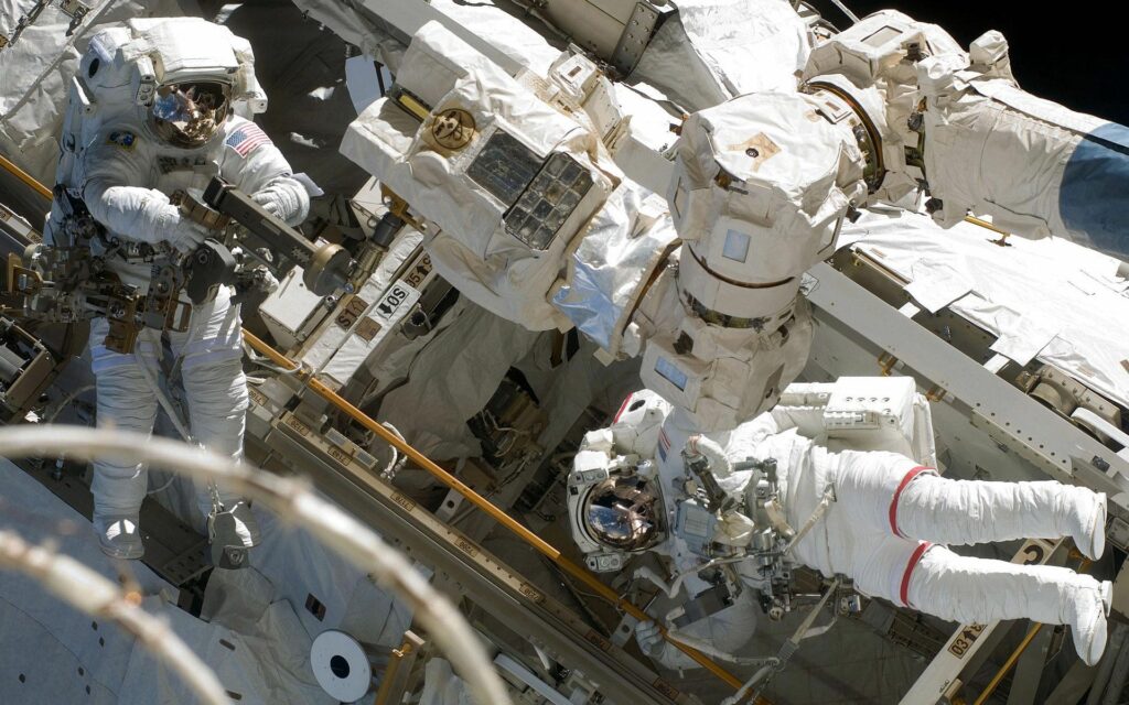 Spacewalk Wallpaper: Cosmonauts Repairing Spacecraft in Weightlessness
