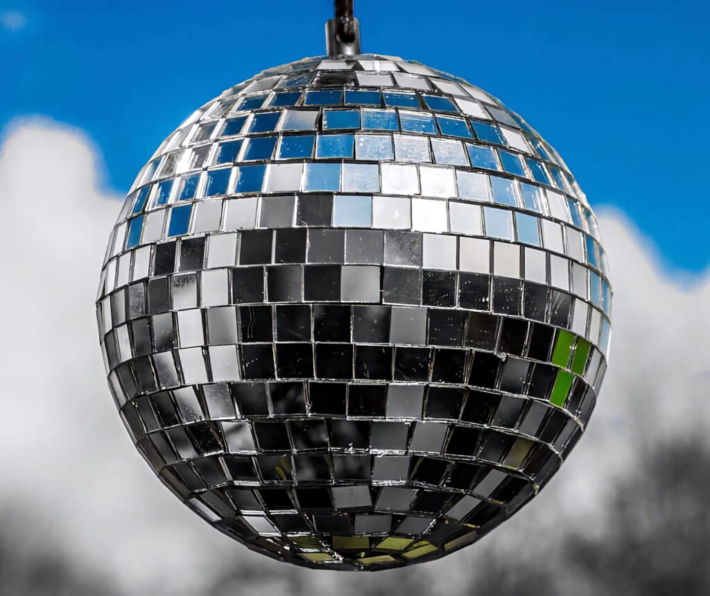 Outdoor disco ball sparkling in sunlight mirror tiles vibrant blue sky festive celebration Wallpaper