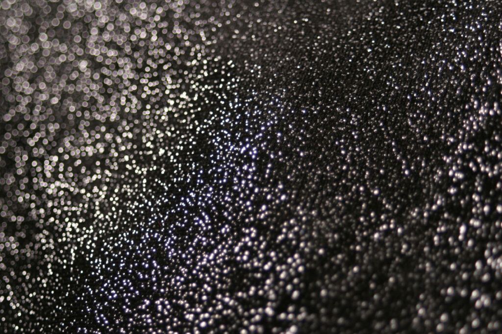 Abstract black glitter wallpaper with shimmering silver light for modern elegant backgrounds
