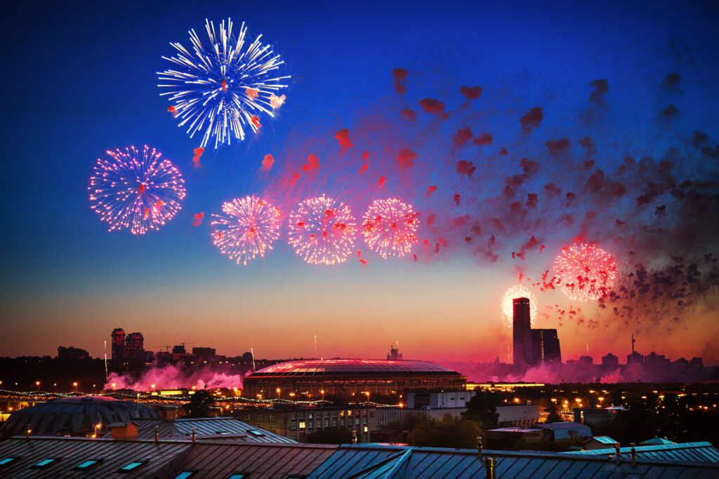 Vivid fireworks over Luzhniki Stadium illuminate Moscow skyline at dusk for Victory Day celebration Wallpaper