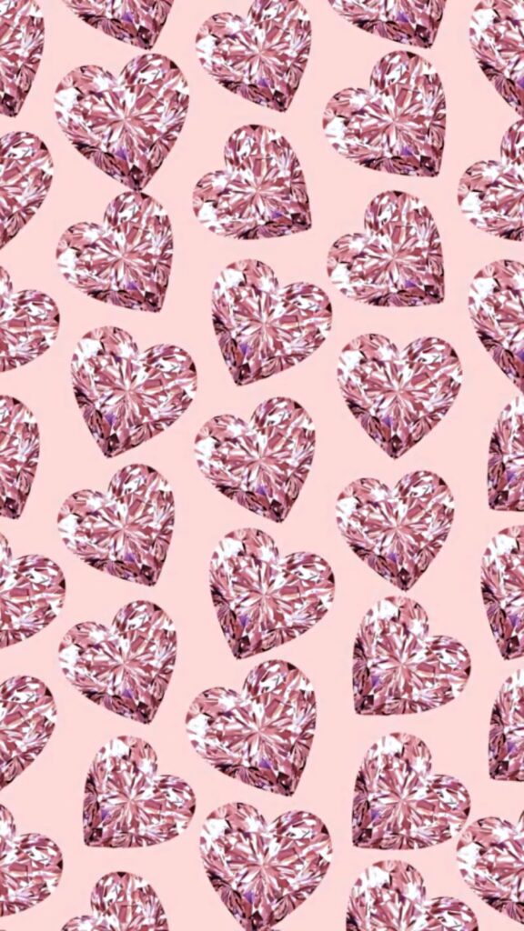 Seamless pattern of sparkling pink heart-shaped diamonds on soft blush luxury wallpaper background