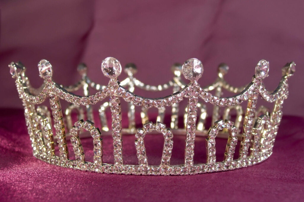 Sparkling rhinestone princess crown on rich magenta background with luxurious royal details Wallpaper