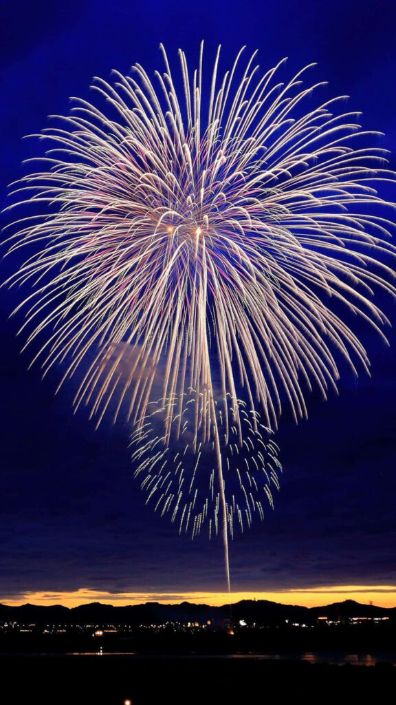 Sparkling Celebration: A New Year iPhone Wallpaper with Fireworks Bursting in the Sky