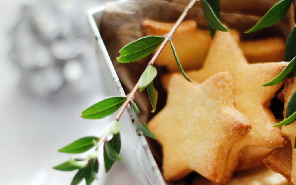 Delightful Starry Cookies Sprinkled on a Fresh White Canvas with Leafy Accents: A Captivating 4K Cookie Wallpaper