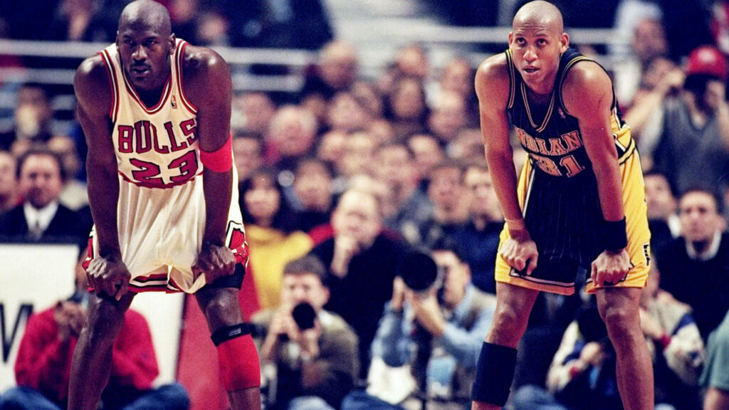 Clash of Titans: Reggie Miller and Michael Jordan Engage in an Epic Battle Wallpaper